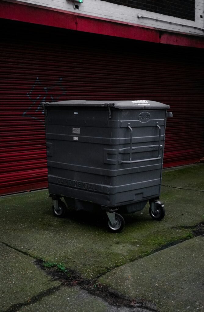 Black refuse bin, highlighting risk of people sleeping rough in refuse containers