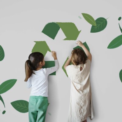 Children drawing a recycling sign on a wall