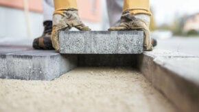 Paving slabs being laid on top of a prepared paving sand base