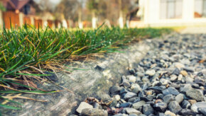 Decorative pea gravel placed next to a patch of grass