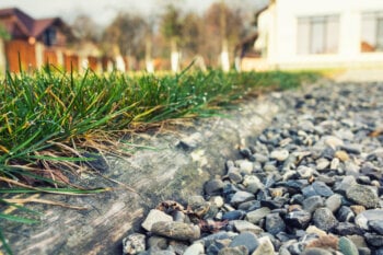 Decorative pea gravel placed next to a patch of grass