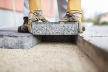 Paving slabs being laid on top of a prepared paving sand base